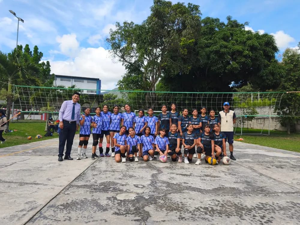 El equipo de vóley del colegio con sus entrenadores, en la cancha.