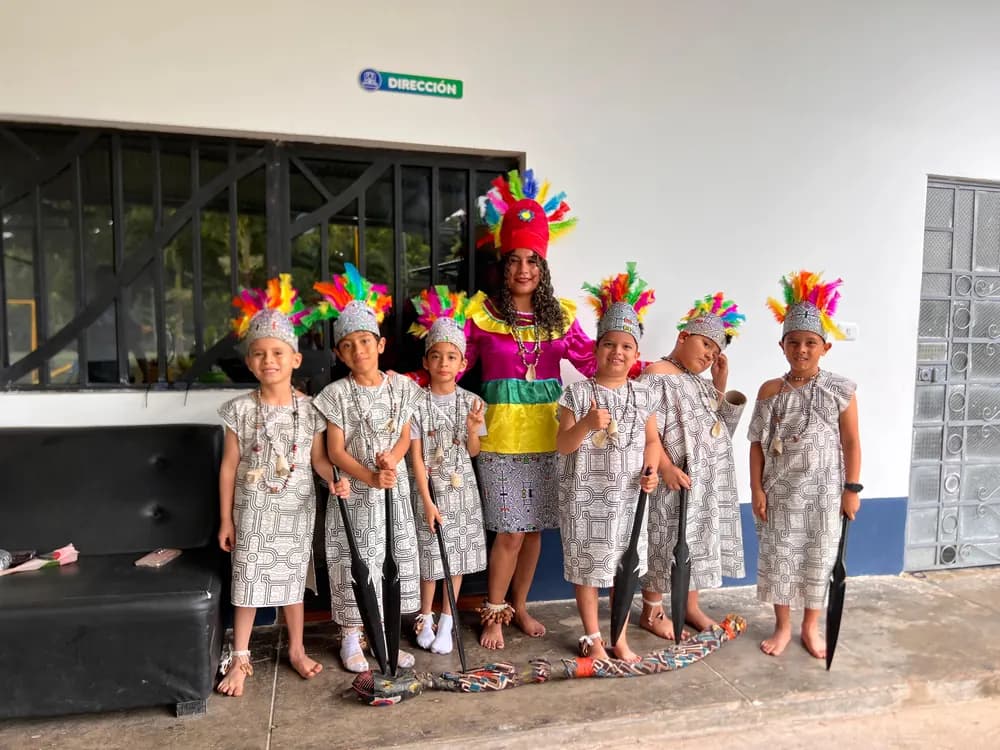 Alumnos con vestimenta shipiba y tocados de plumas, listos para una presentación de danzas.
